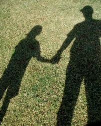 Shadows of an adult and child holding hands