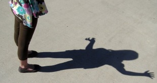 A woman casts a shadow on the ground.